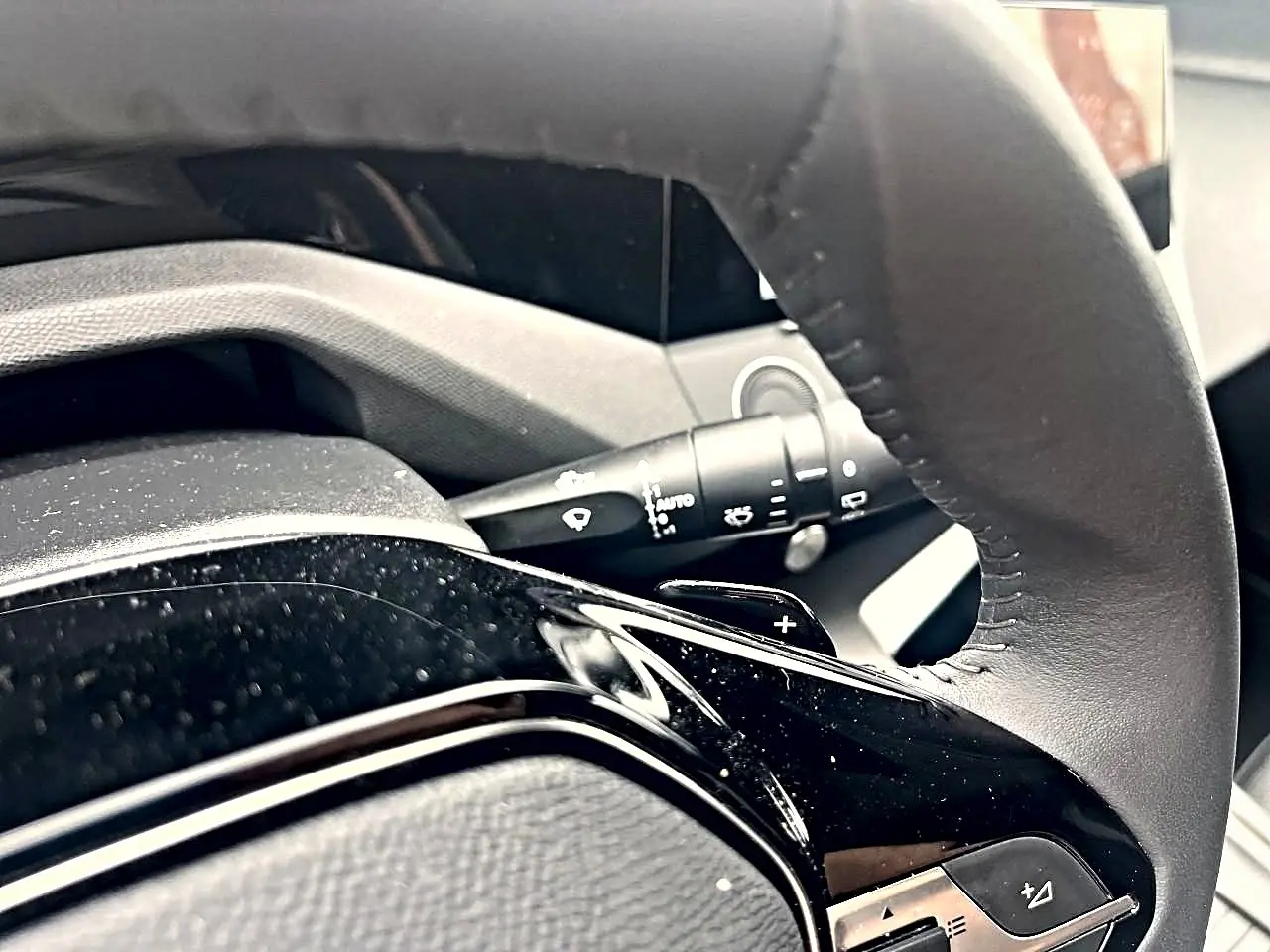 Gros plan sur le volant noir de la Peugeot 308 2025 avec commandes intégrées et palettes au volant.