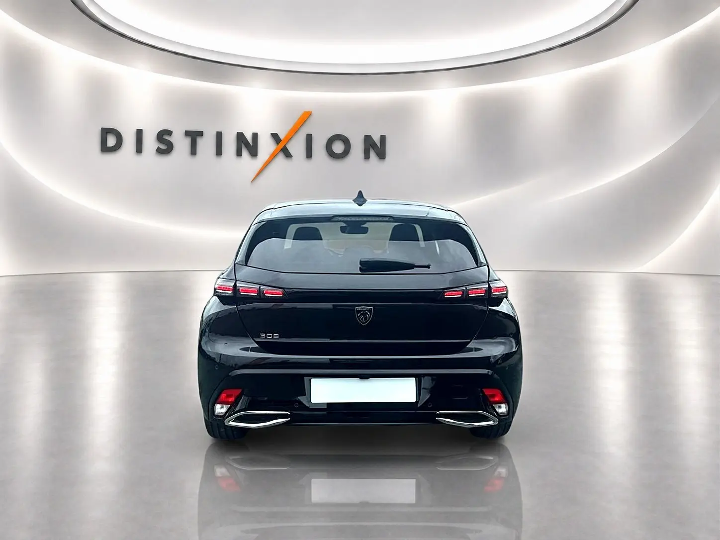 Vue arrière d'une Peugeot 308 noire 2025 avec feux LED et double sortie d'échappement chromée dans un showroom.