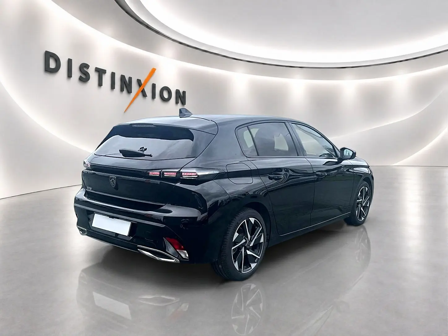 Peugeot 308 noire vue 3/4 arrière droit dans un showroom lumineux avec jantes alliage distinctives.