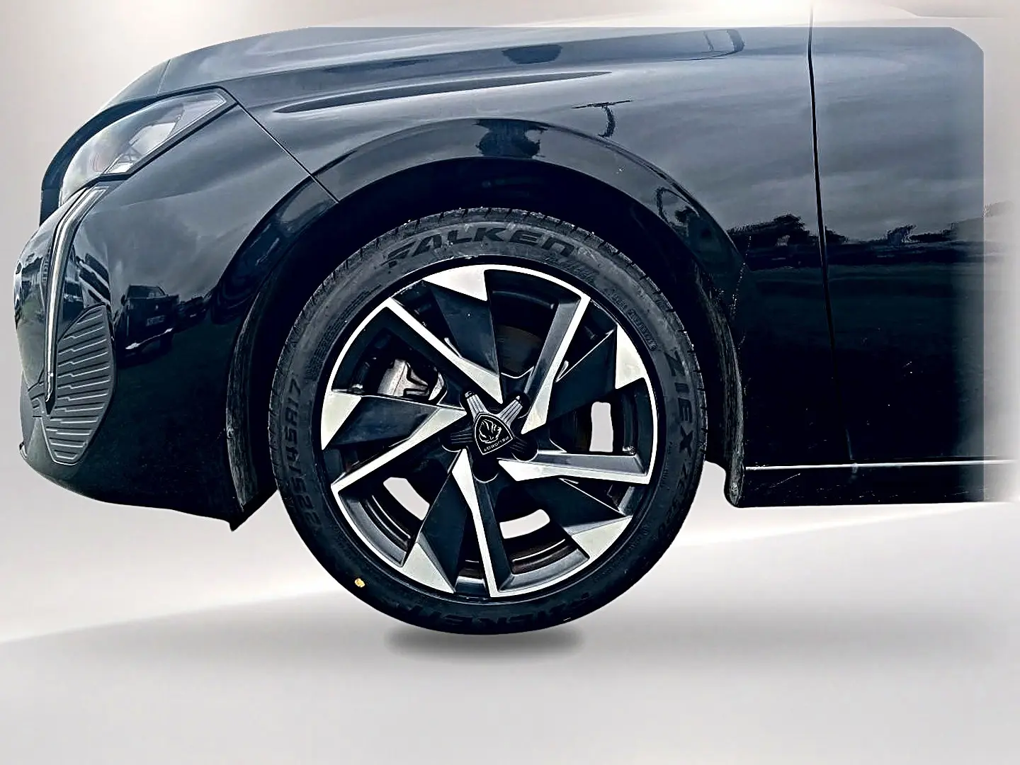 Gros plan sur la roue avant gauche d'une Peugeot 308 noire 2025 avec jante alliage au design moderne.