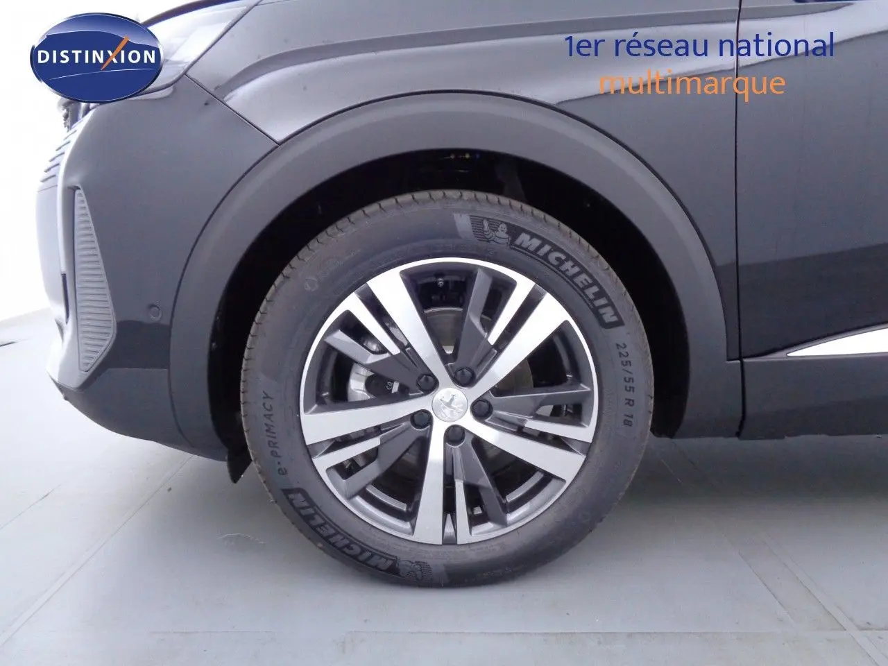 Gros plan sur la roue avant gauche d’un Peugeot 3008 noir métal 2023 avec jante alliage biton et pneu Michelin.