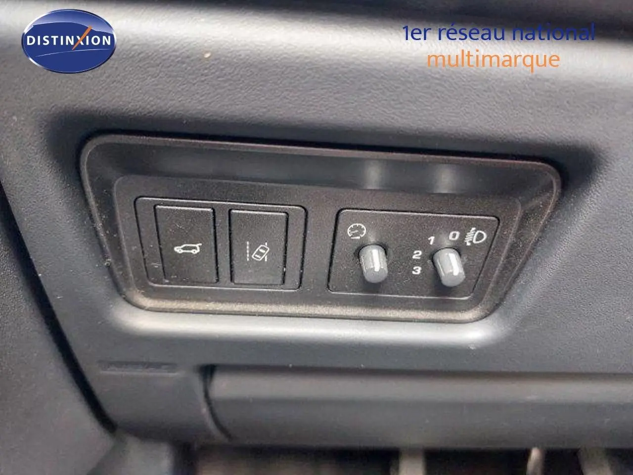 Gros plan sur les commandes de réglage des phares et assistance au stationnement du Range Rover Evoque blanc 2018.