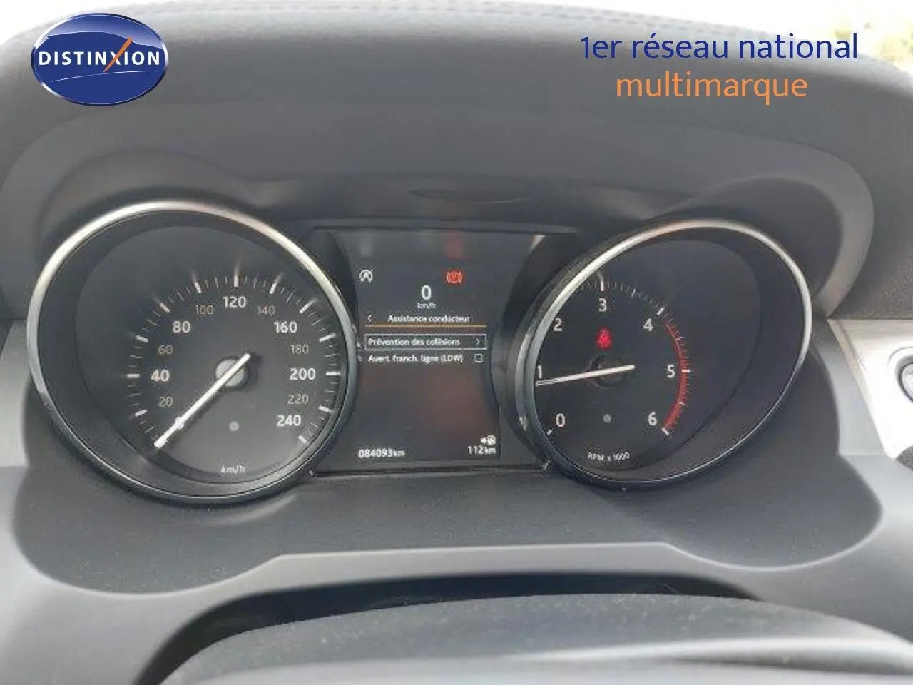 Tableau de bord du Range Rover Evoque blanc 2018, affichant compteur de vitesse et compte-tours au ralenti.