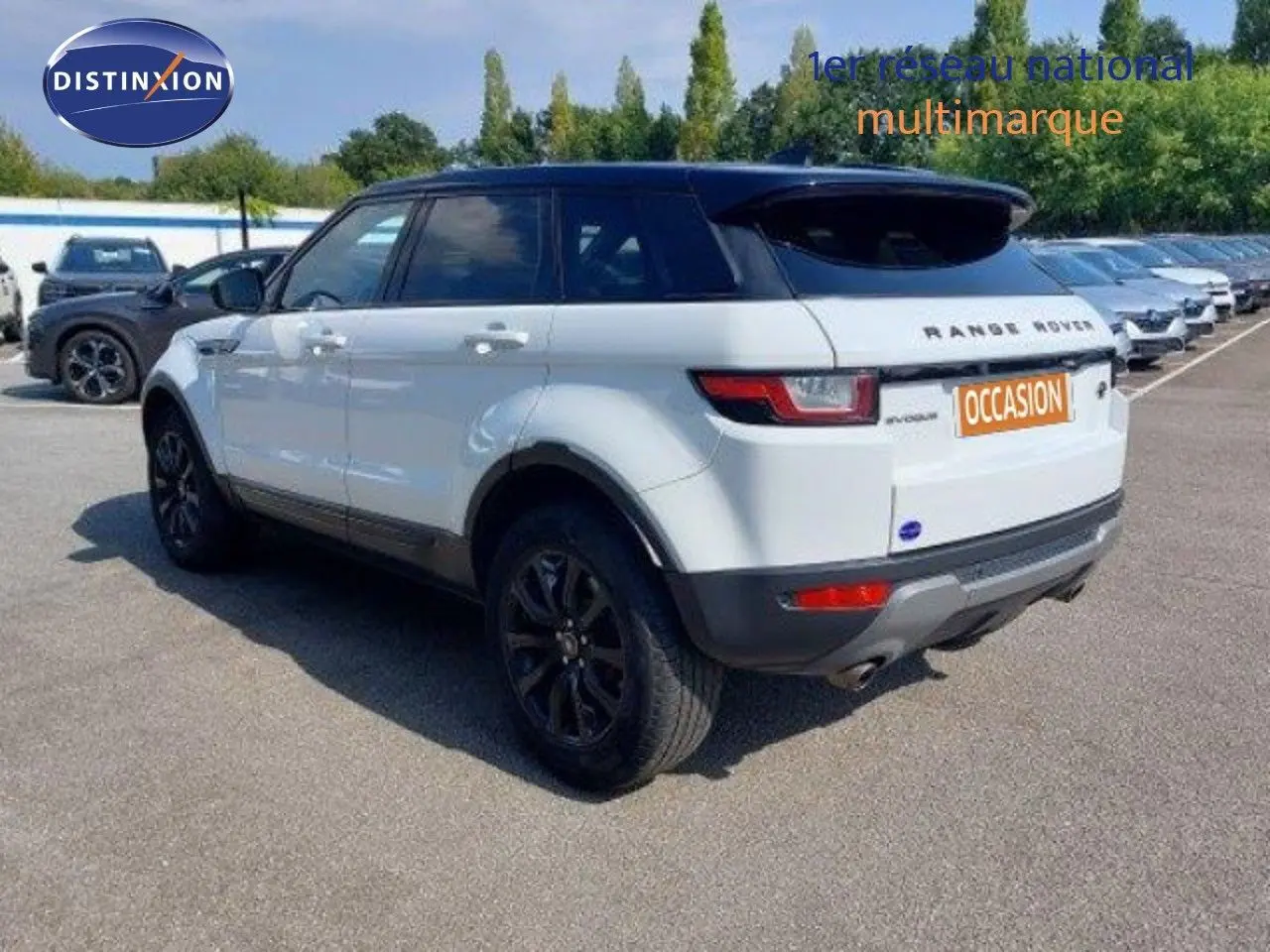 Vue 3/4 arrière droite d'un Range Rover Evoque blanc 2018 avec jantes noires et toit noir contrasté.