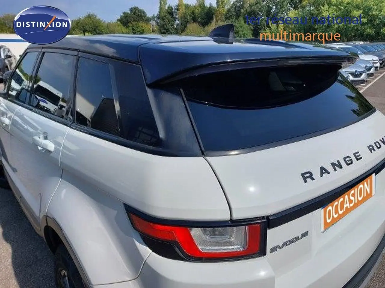 Vue 3/4 arrière droite d'un Range Rover Evoque blanc 2018 avec toit noir et feux arrière distinctifs rouges.