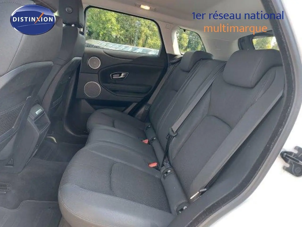 Vue intérieure arrière côté droit du Range Rover Evoque blanc de 2018, montrant les sièges arrière en tissu noir.