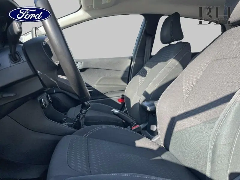 Vue intérieure côté conducteur de la Ford Fiesta 1.1 Titanium 2021 avec sièges tissu noir et levier de vitesses cuir.