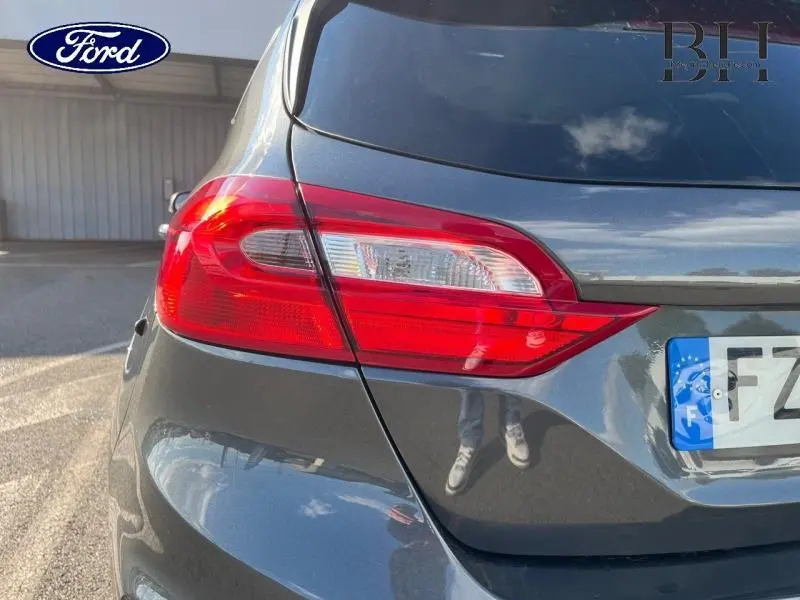 Gros plan sur le feu arrière gauche d'une Ford Fiesta 2021 gris Fashion Magnetic, avec reflet sur la carrosserie lisse.