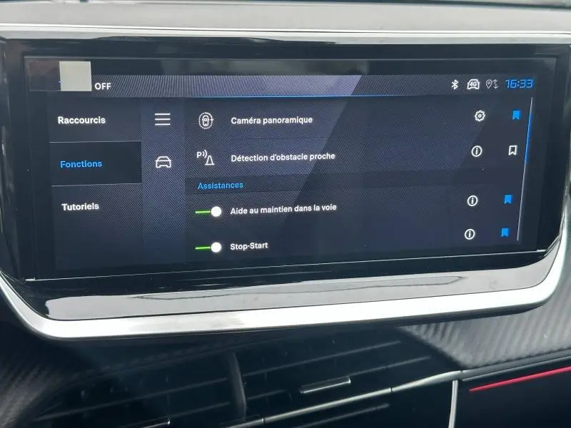 Écran tactile central du Peugeot 208 1.2 Hybrid 110ch GT 2025 affichant les options d'assistance à la conduite.