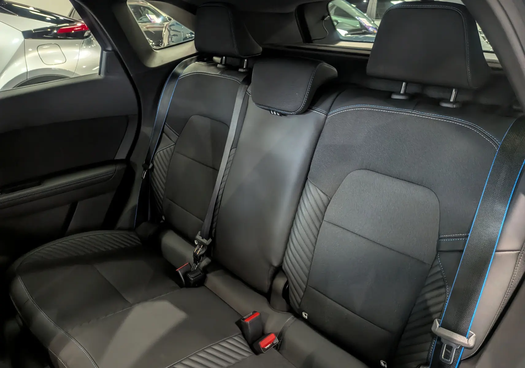 Vue intérieure sur la banquette arrière en cuir noir avec surpiqûres bleues du Renault SYMBIOZ E-Tech hybride 2025.