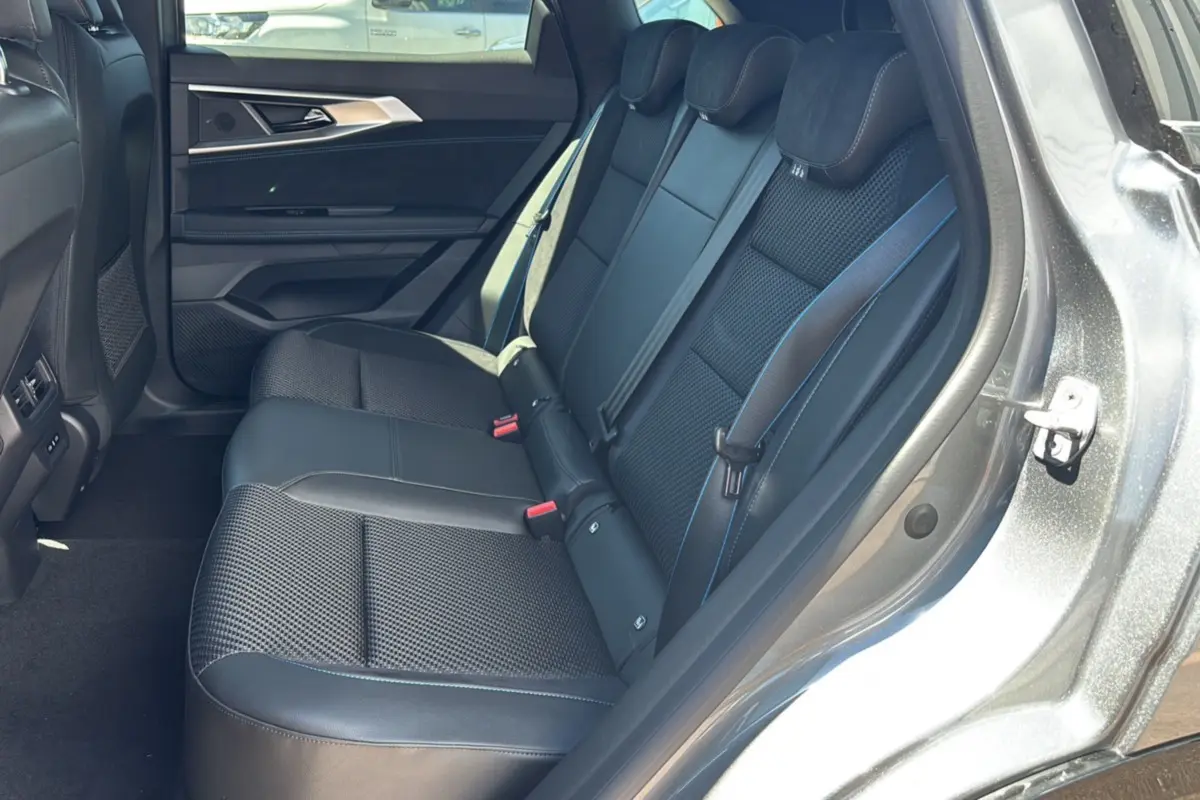 Vue intérieure arrière droite des sièges semi-alcantara noirs avec surpiqûres bleues du Renault Austral E-Tech 200 Esprit Alpine 2025.