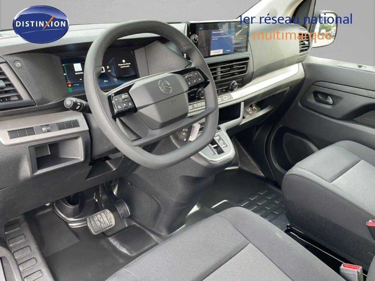 Vue intérieure côté conducteur du Citroën Jumpy cabine approfondie, tableau de bord moderne avec écran tactile et volant multifonction.