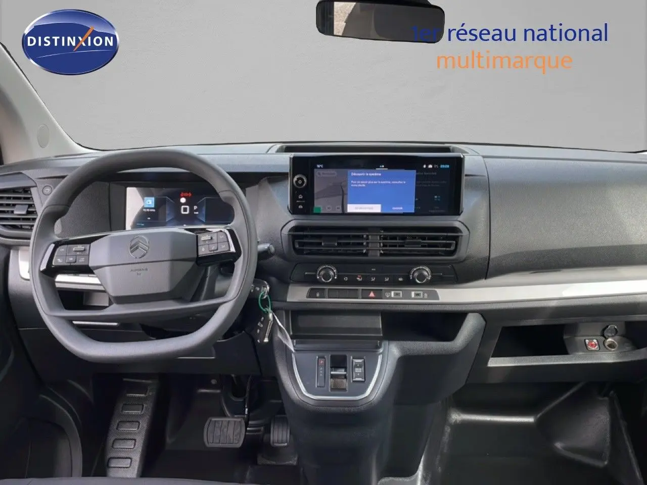 Vue intérieure du tableau de bord et volant du Citroën Jumpy cabine approfondie gris titane, avec écran tactile central.