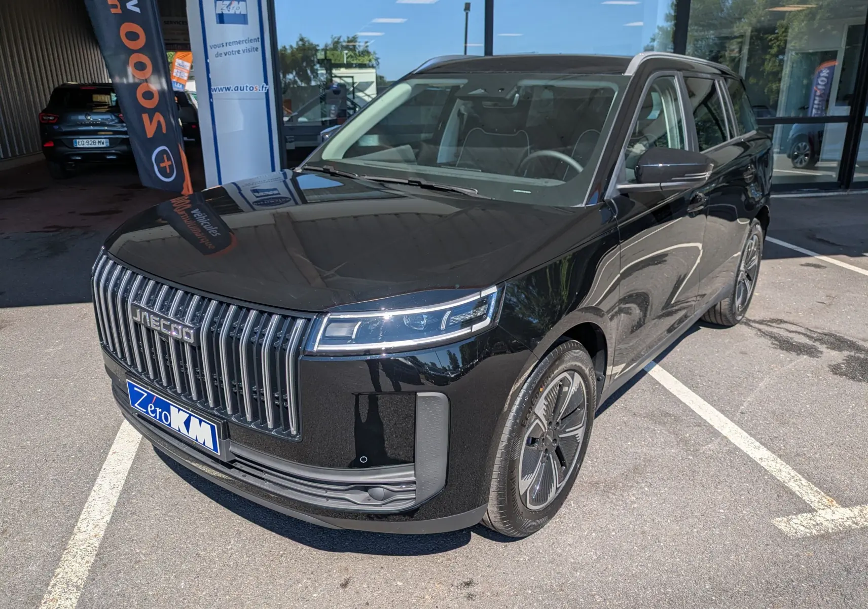 Vue 3/4 avant du JAECOO J5 noir carbone métal avec calandre verticale chromée et jantes design en concession.