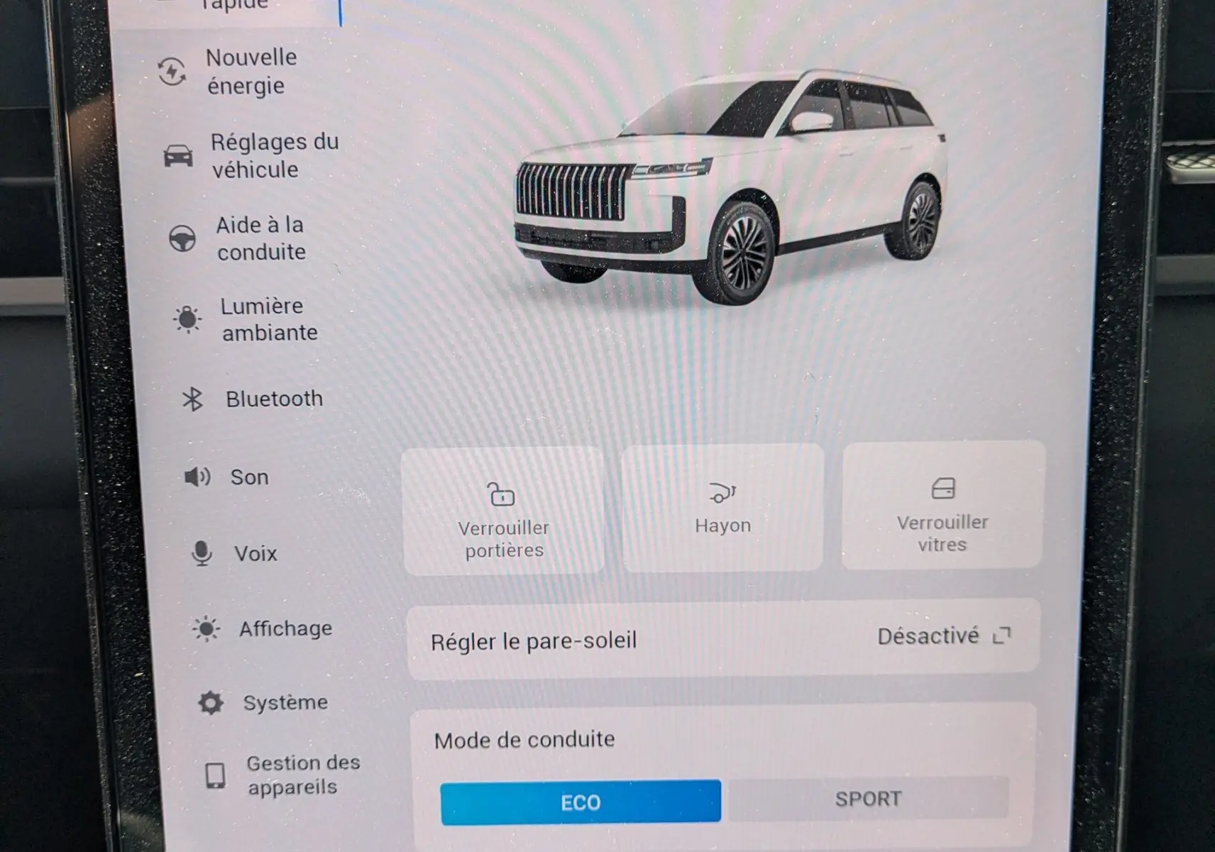 Écran tactile intérieur affichant les réglages du JAECOO J5 avec illustration 3/4 avant du SUV blanc.
