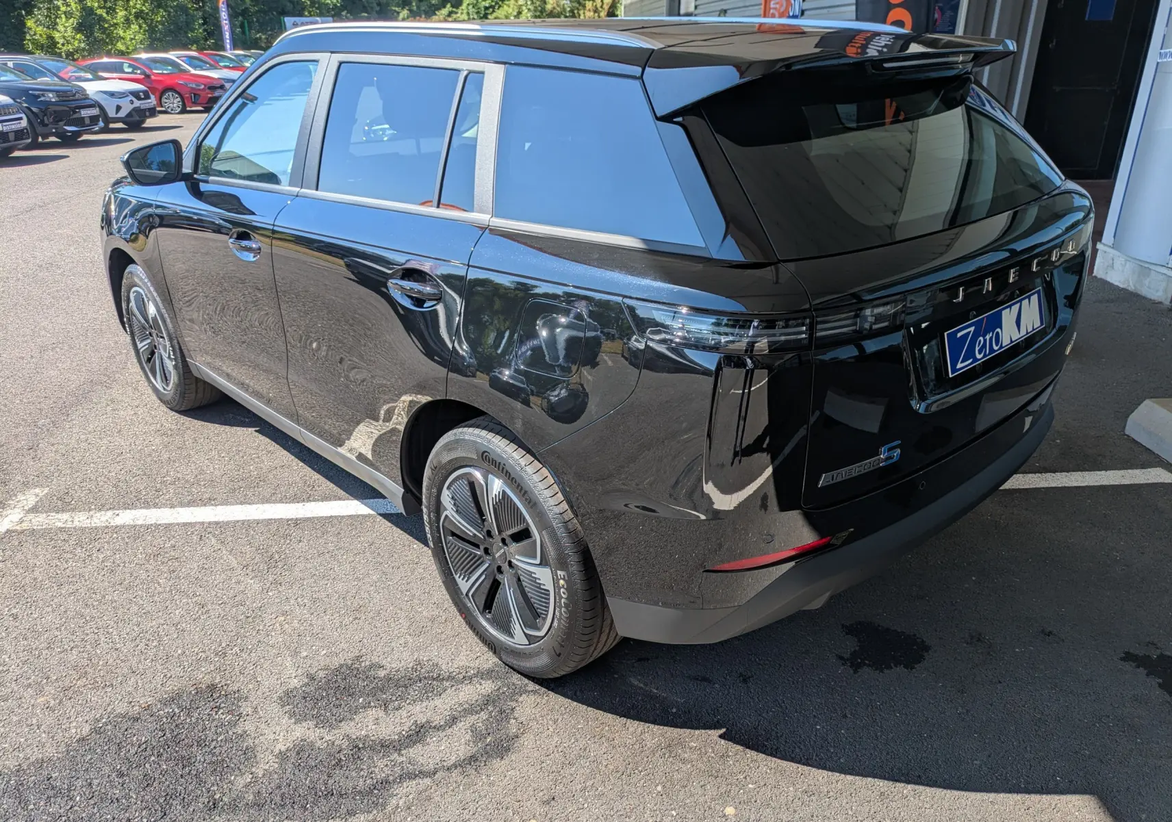 Vue 3/4 arrière droite du SUV JAECOO J5 noir carbone métal avec jantes modernes et vitres teintées.