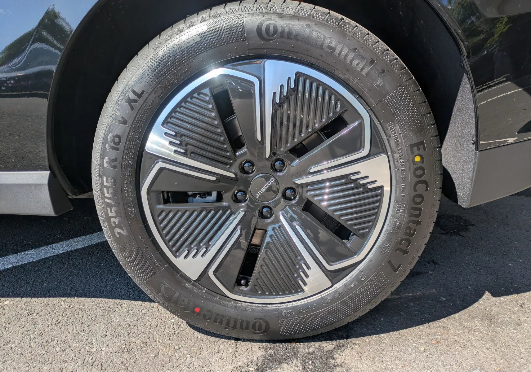 Gros plan sur la roue avant gauche du JAECOO J5 noir carbone, jante alliage au design moderne et pneu Continental EcoContact.