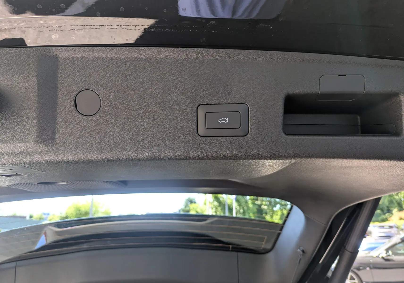 Gros plan sur le bouton d'ouverture électrique du coffre, à l'intérieur du hayon du JAECOO J5 noir carbone 2026.