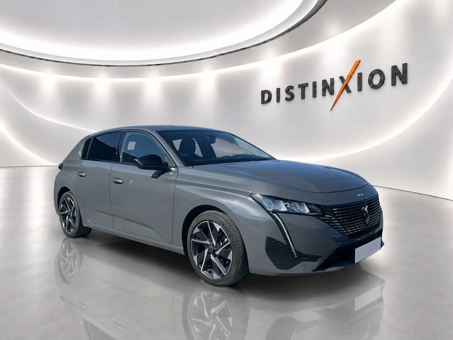 Peugeot 308 gris artense vue 3/4 avant droit en showroom avec jantes alliage et calandre noire distinctive.
