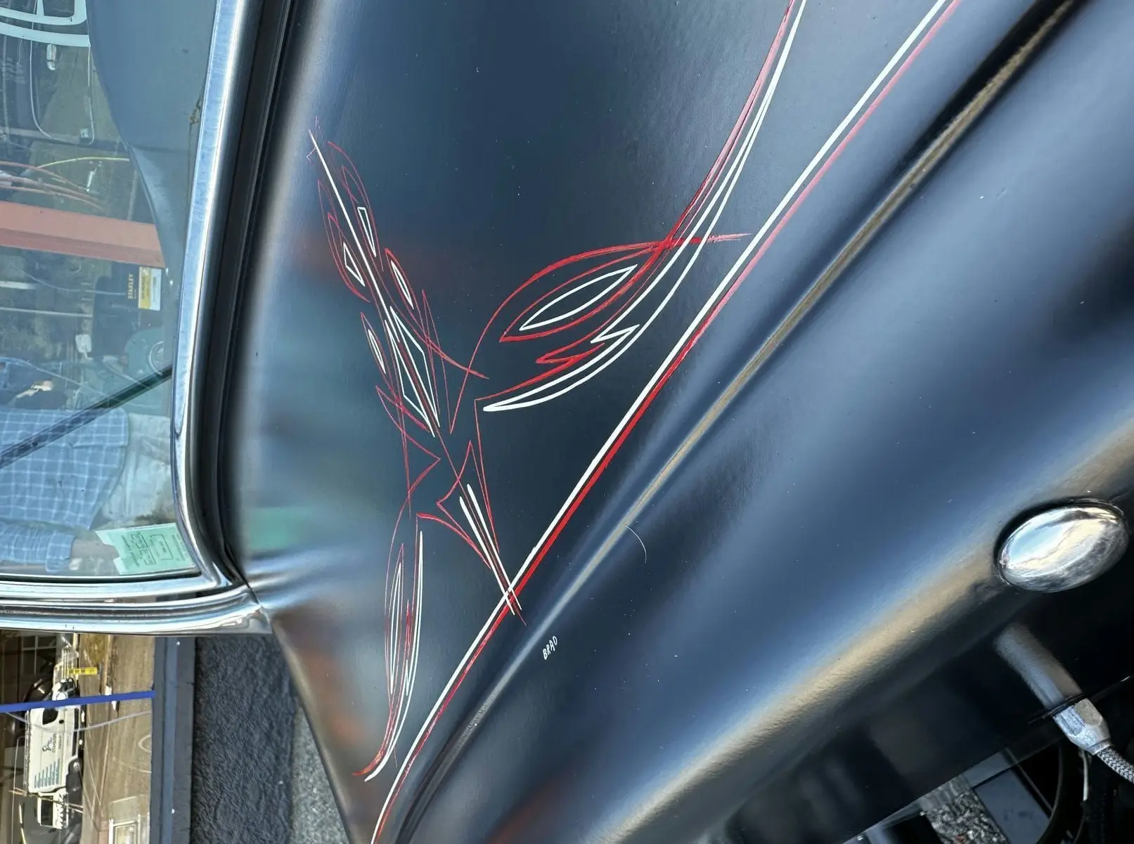 Détail de la peinture noire avec liserés rouges et blancs faits à la main sur la portière gauche d'une Ford T Hot Rod 1923.