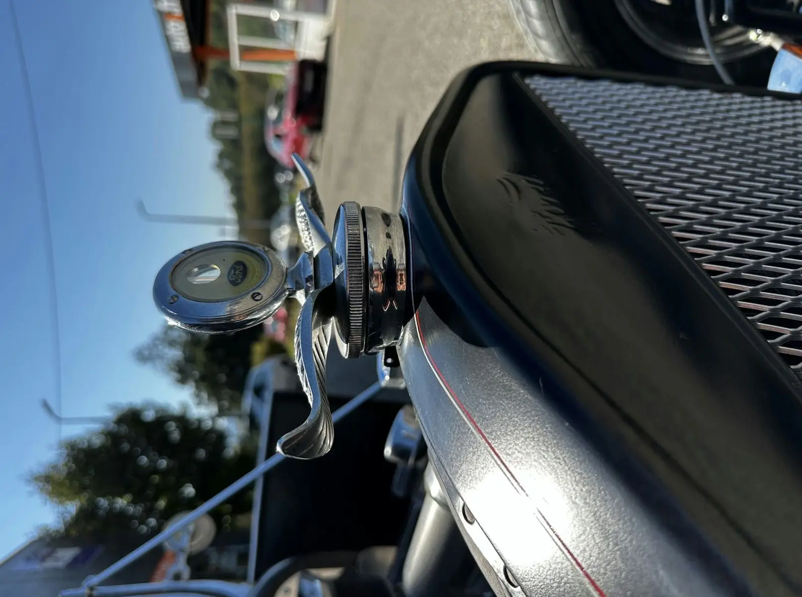 Gros plan sur le capot noir du Ford T Hot Rod 1923 avec liserés rouges et ornement chromé en forme d'hélice.