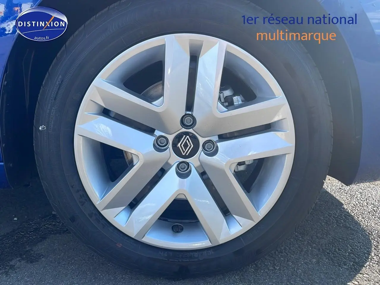 Gros plan sur la jante alliage argentée d'une Renault Clio V Bleu Iron, avec logo Renault au centre.
