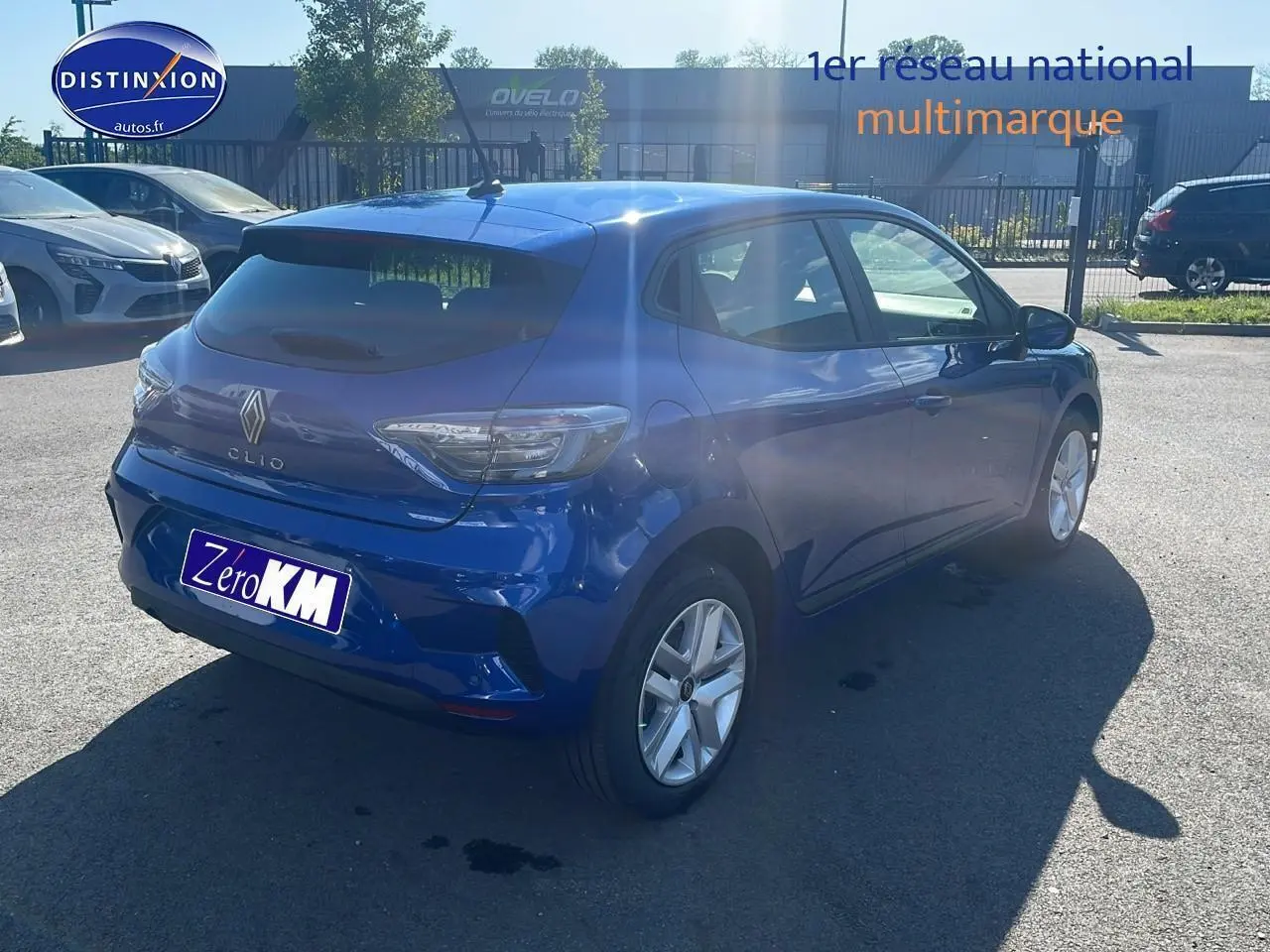 Vue 3/4 arrière droite d'une Renault Clio V bleu iron stationnée en extérieur avec jantes argentées.