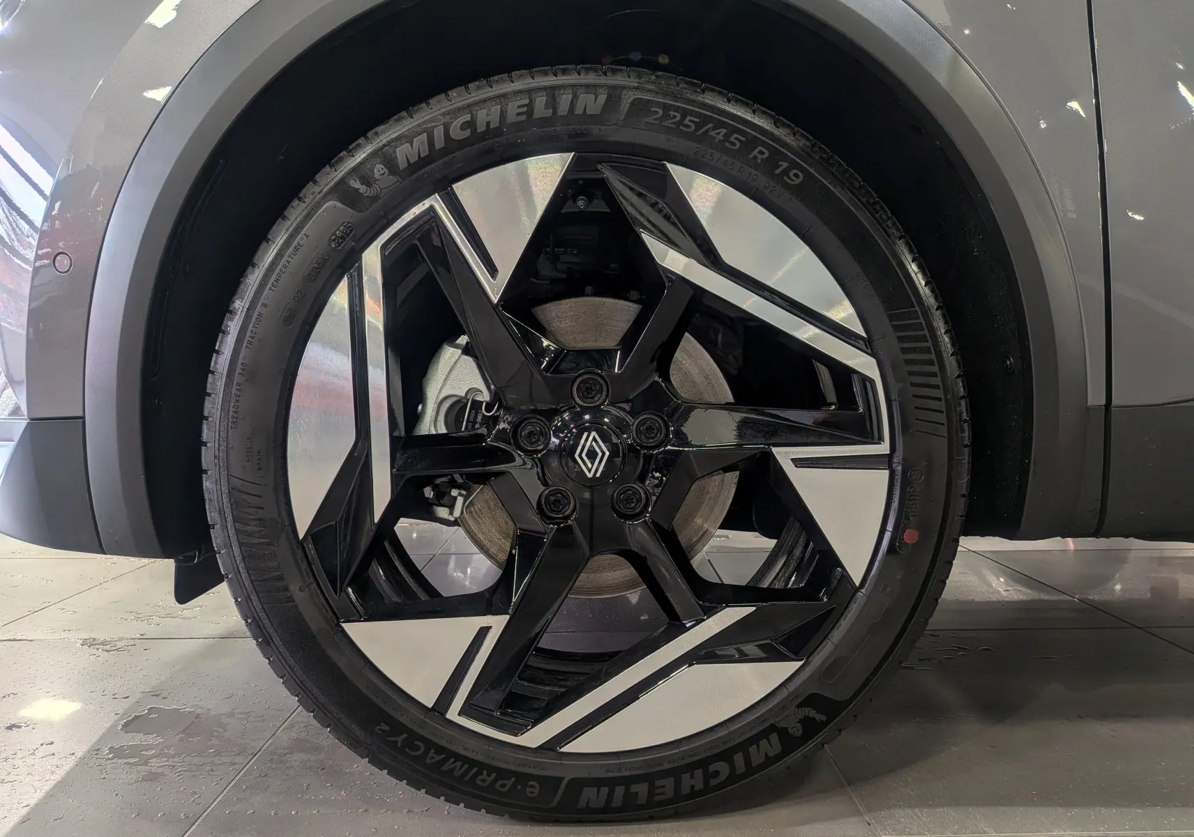 Gros plan sur la roue avant droite gris Cassiopé du Renault SYMBIOZ avec jante noire et argentée au design géométrique.