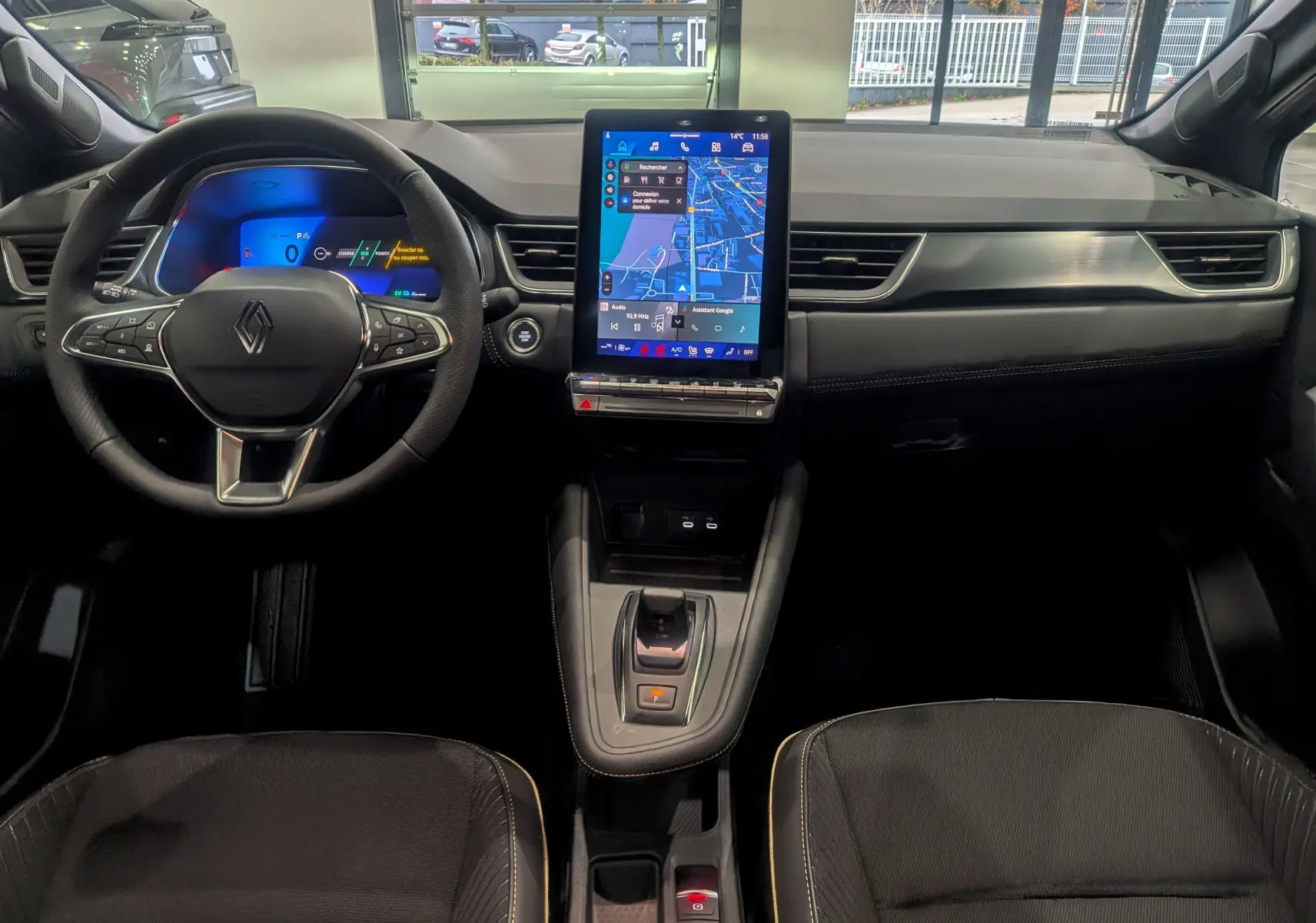 Vue intérieure avant du Renault SYMBIOZ gris Cassiopé, avec tableau de bord numérique et écran tactile central vertical.