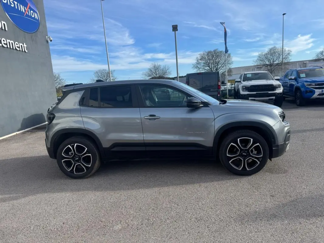 Vue de profil côté gauche du Jeep Avenger gris 2025 avec jantes alliage noires et détails noirs sur les bas de caisse.