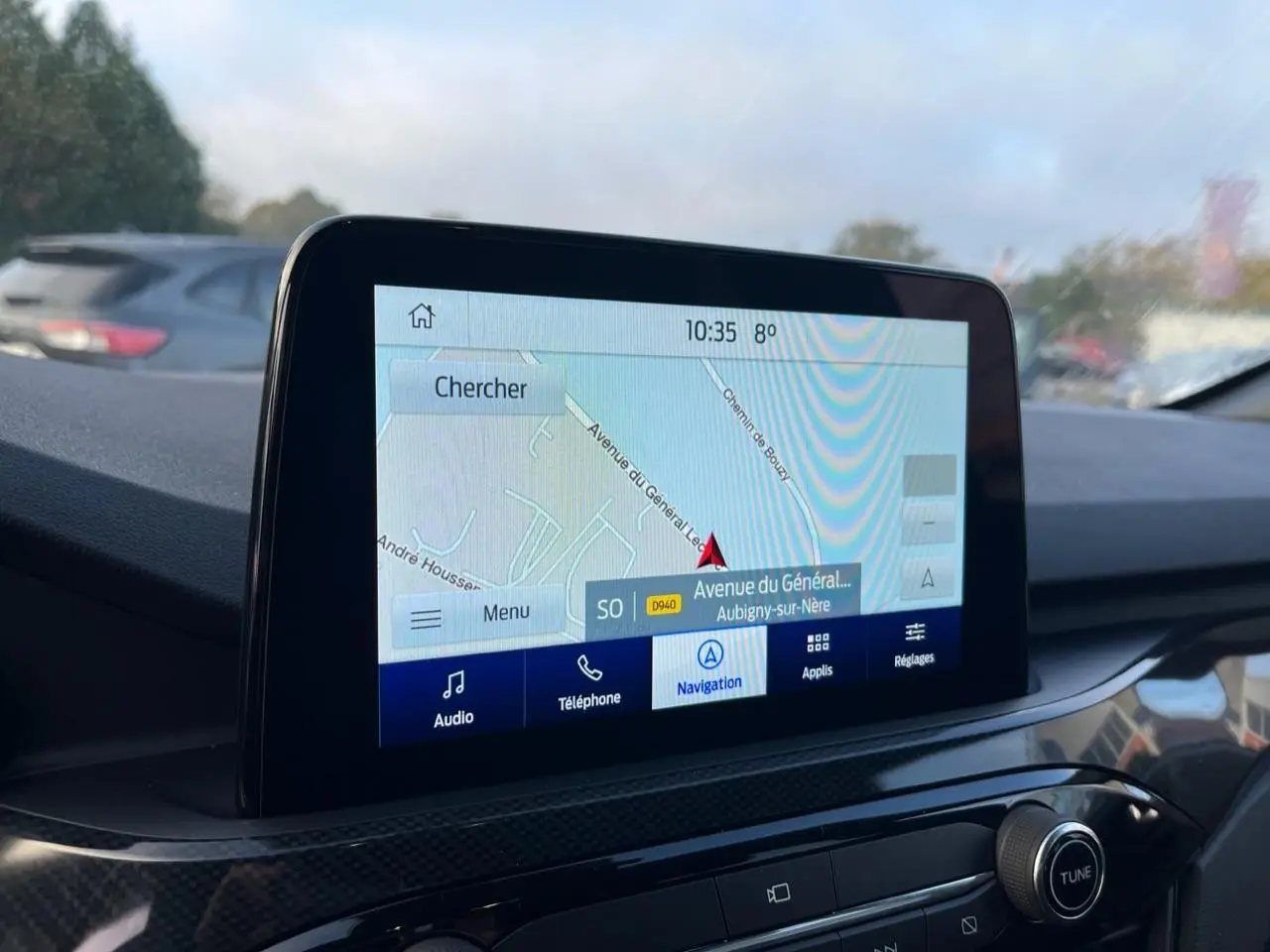Écran tactile central du Ford Kuga 2022 affichant la navigation, avec tableau de bord noir et finitions carbone.