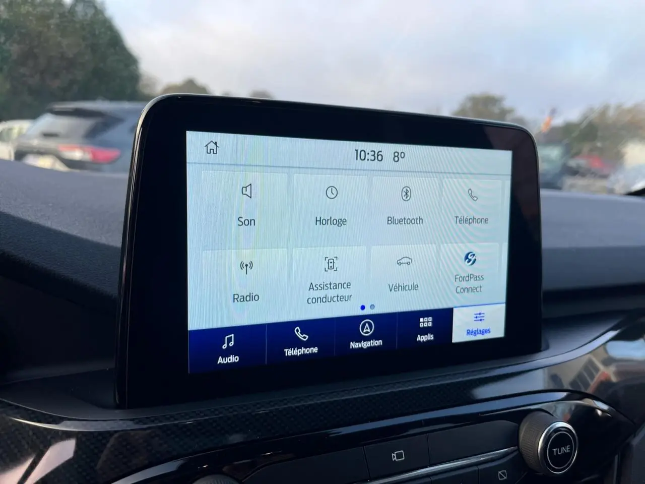Écran tactile central du Ford Kuga 1.5 EcoBoost 2022 affichant les options audio et navigation, intérieur noir.