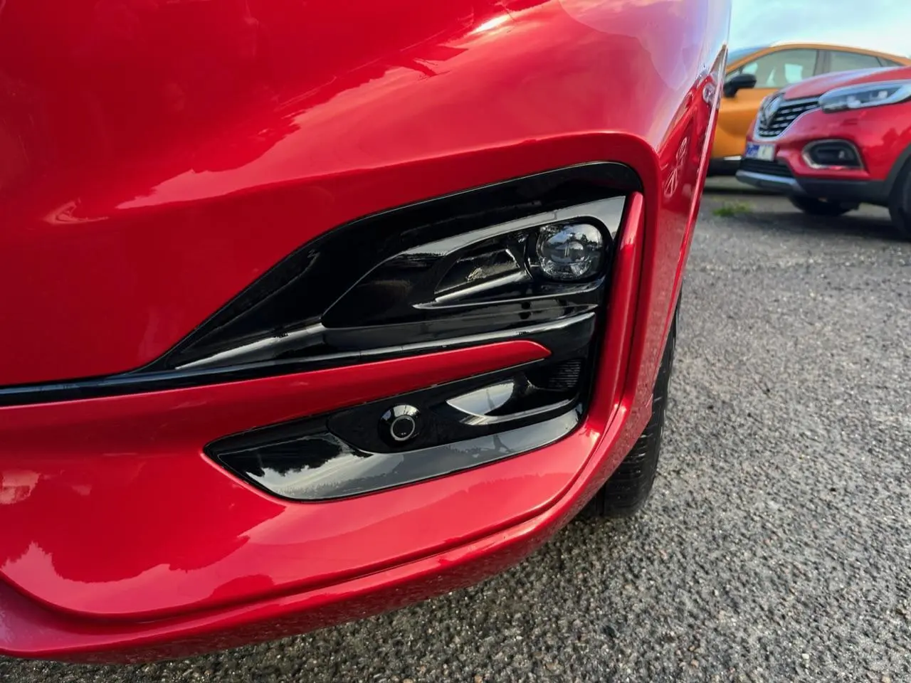 Gros plan sur le projecteur antibrouillard avant droit du Ford Kuga 1.5 EcoBoost rouge Lucifer avec insert noir brillant.