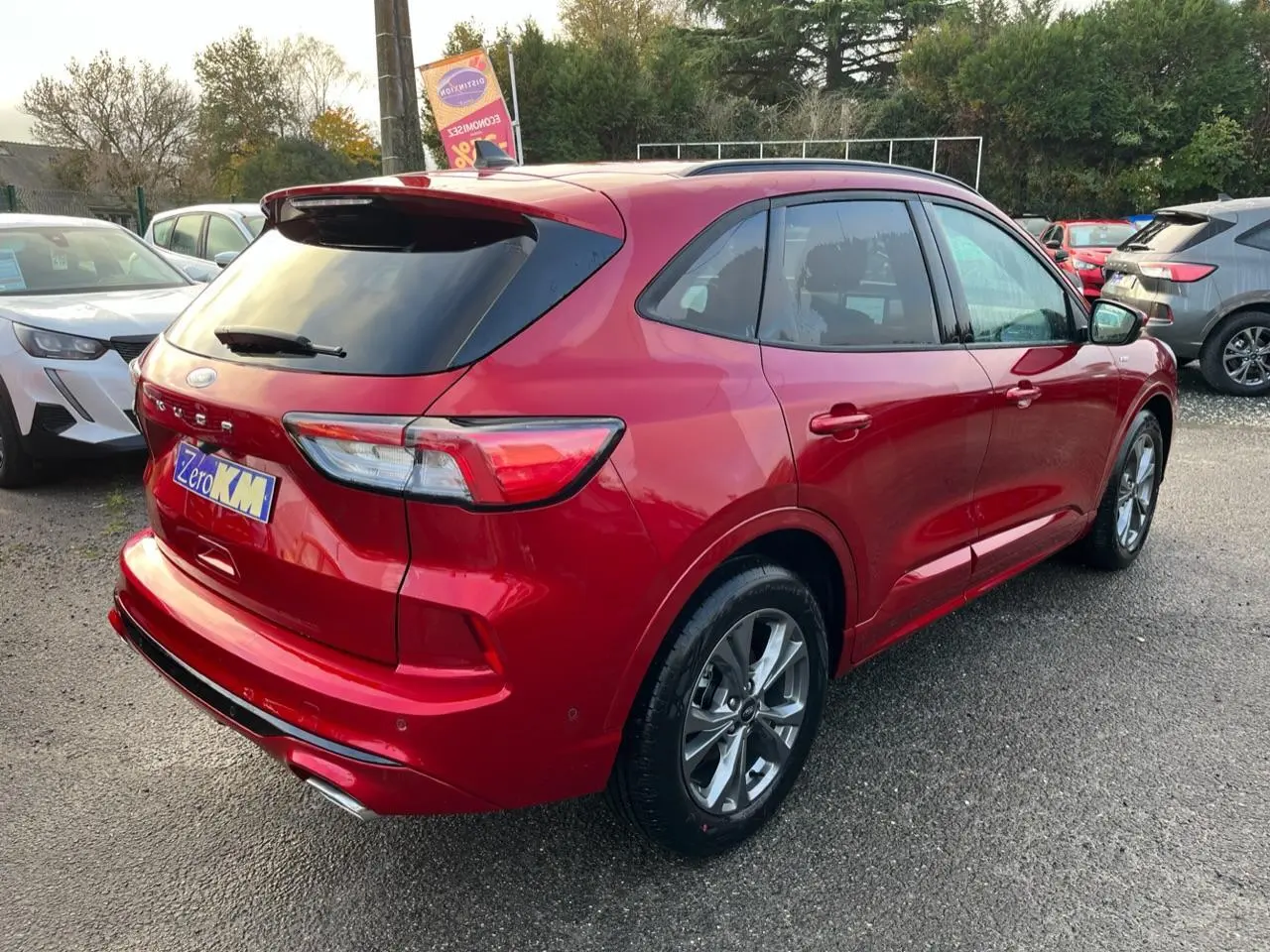 Vue 3/4 arrière droite d'un Ford Kuga 1.5 EcoBoost ST-Line rouge Lucifer avec vitres arrière surteintées et jantes alliage 18 pouces.