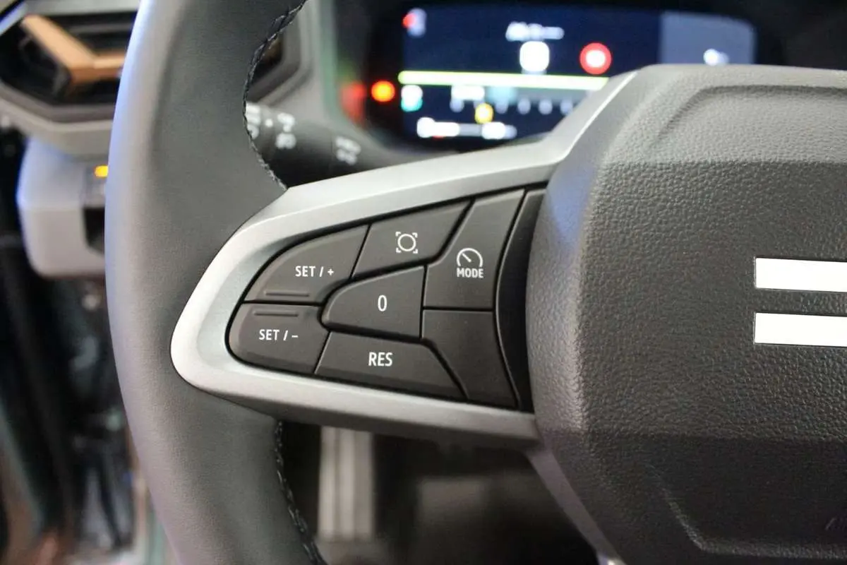 Gros plan sur le volant cuir noir de la Dacia Bigster 2026, montrant les commandes de régulateur de vitesse à gauche.