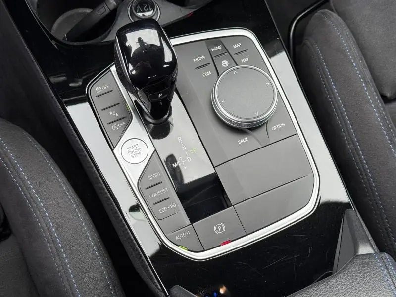 Vue rapprochée de la console centrale noire brillante avec levier de vitesses et commandes du BMW Série 1 118dA M Sport.
