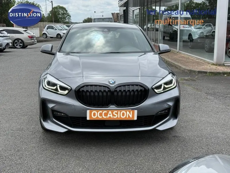 Vue avant d'une BMW Série 1 118dA M Sport en Saphirschwarz métallisé avec calandre noire et phares LED allumés.