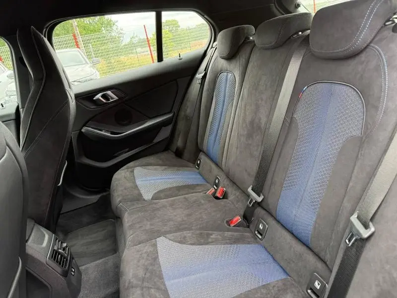 Vue intérieure arrière côté droit des sièges sport en tissu et similicuir noir avec inserts bleus de la BMW Série 1 118dA M Sport 2022.