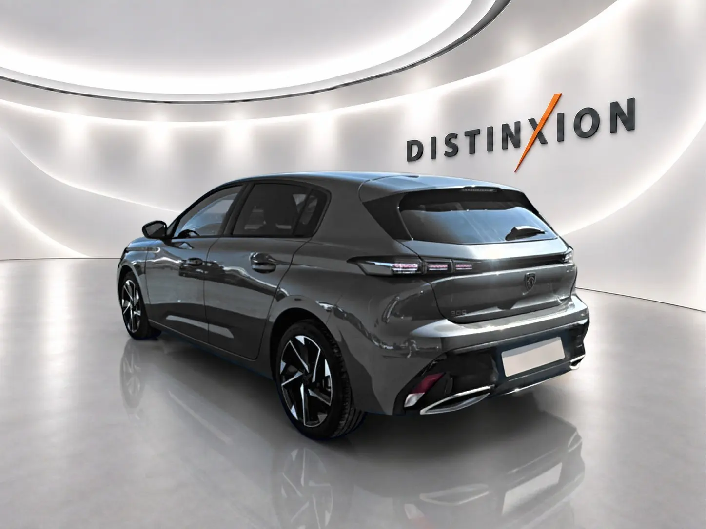Peugeot 308 gris selenium vue 3/4 arrière droit dans un showroom lumineux avec jantes alu et feux LED.