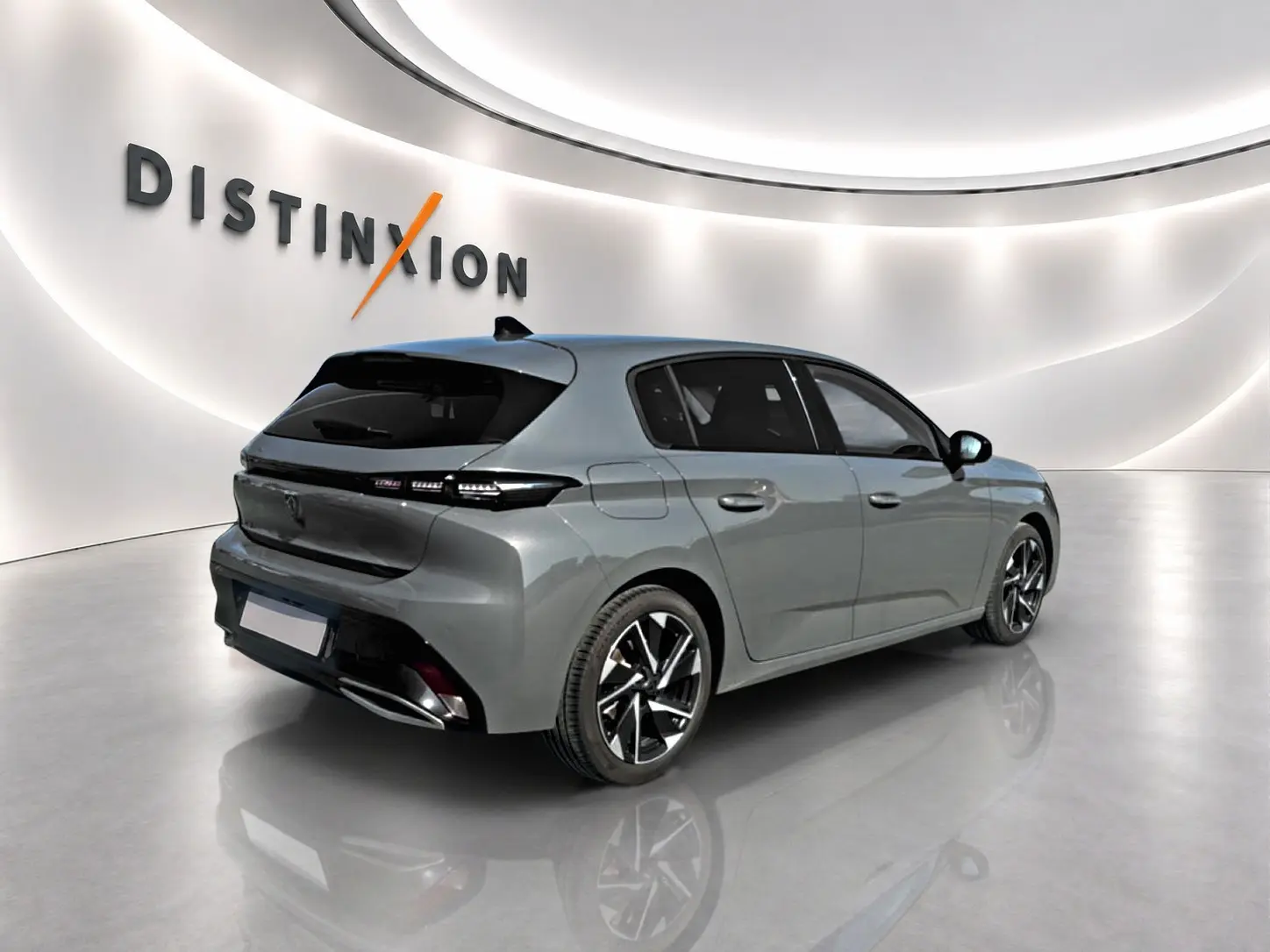 Peugeot 308 gris selenium vue 3/4 arrière droit dans un showroom lumineux avec jantes alu noires et chromées.
