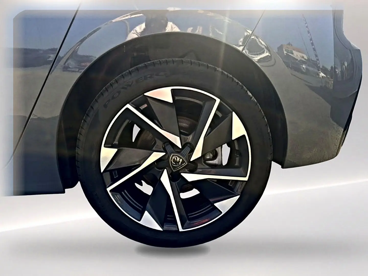 Gros plan sur la roue arrière droite d’une Peugeot 308 gris selenium avec jante alu au design moderne.