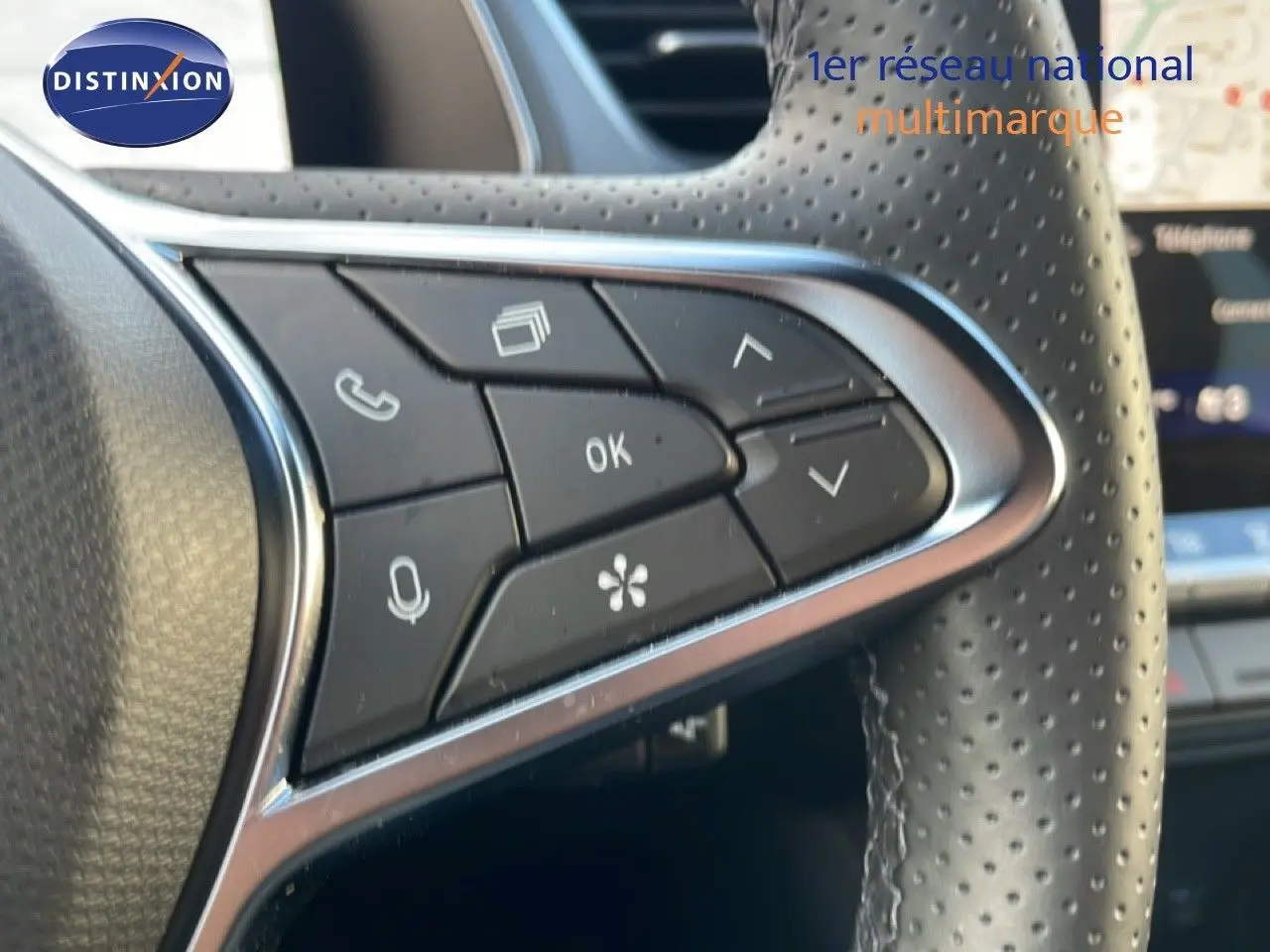 Gros plan sur les commandes au volant en cuir perforé du Renault Symbioz gris cassiopée métal, version hybride 2025.