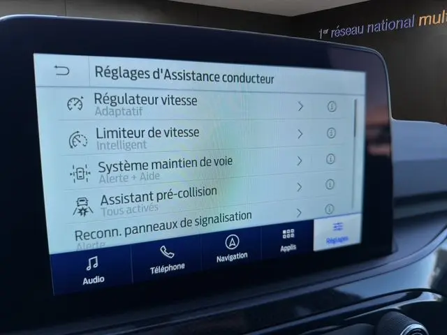 Écran tactile intérieur du Ford Kuga 2024 montrant les réglages d’assistance conducteur avec interface moderne.