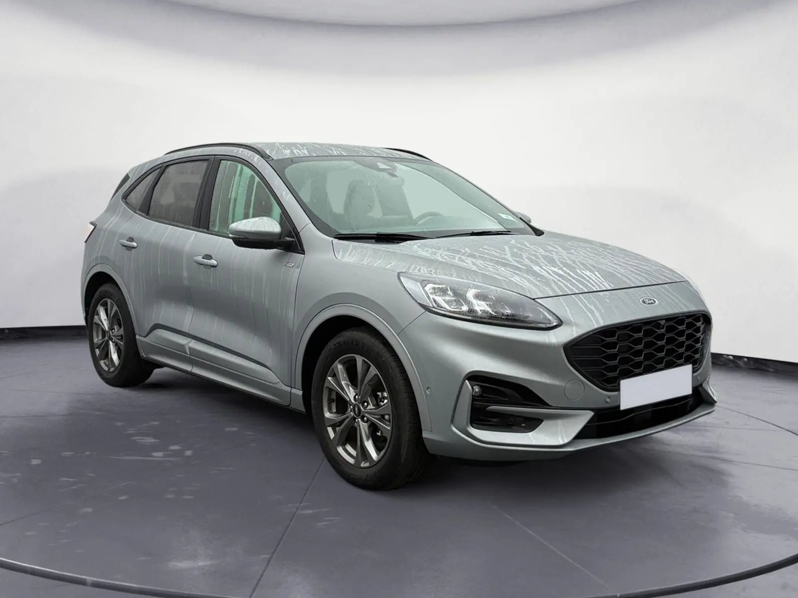 Vue 3/4 avant droit d'un Ford Kuga 2024 gris avec calandre noire et jantes alliage, version hybride essence ST-Line X.