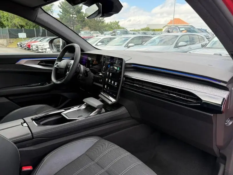 Vue intérieure côté conducteur du Renault Austral 1.2 E-Tech rouge, avec écran tactile vertical et finition Techno 2025.
