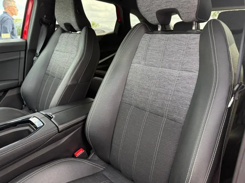 Vue rapprochée des sièges avant en tissu gris et cuir noir du Renault Austral 2025, intérieur sobre et moderne.