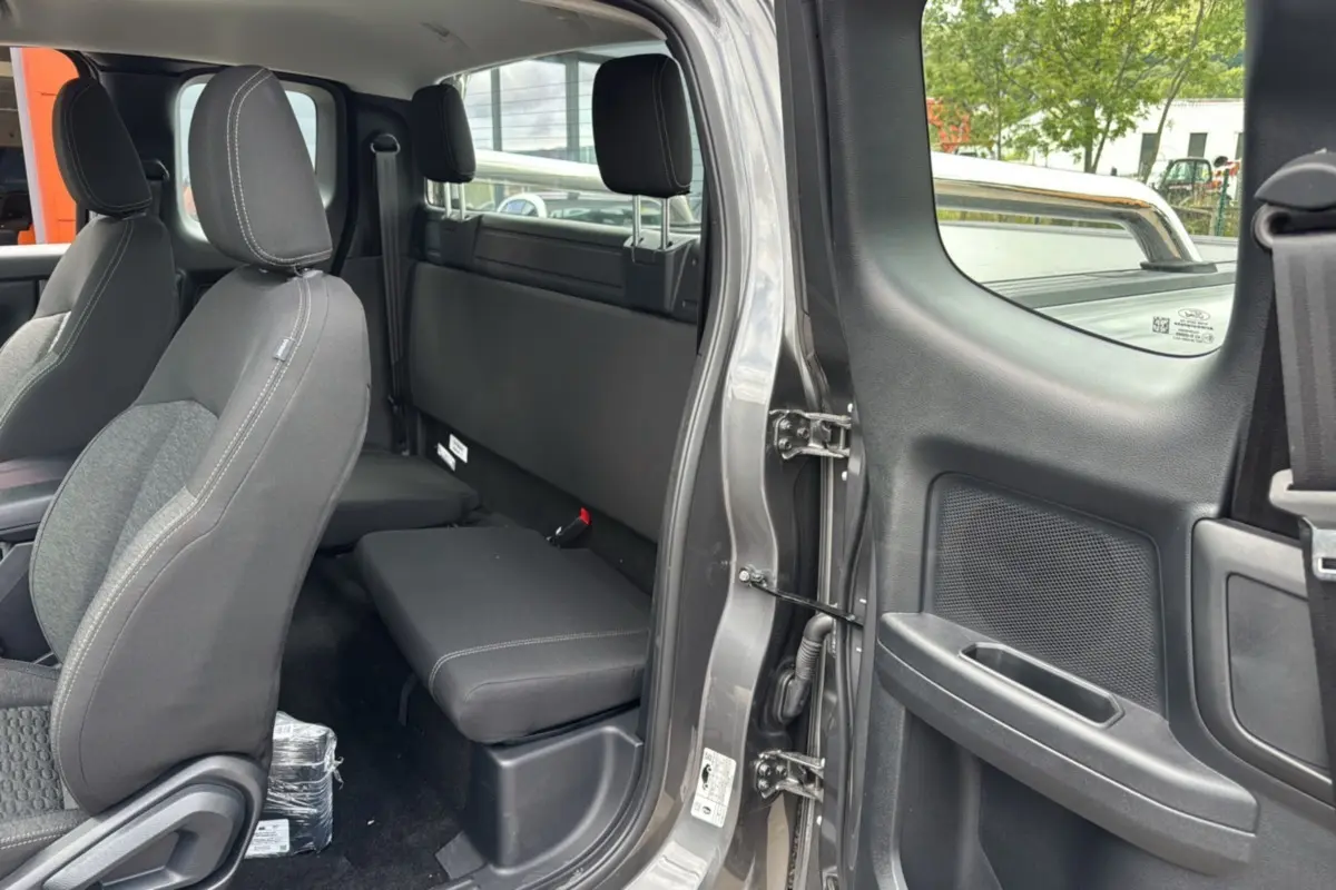 Vue intérieure côté arrière droit du Ford Ranger gris carbone, montrant les sièges et la porte ouverte.
