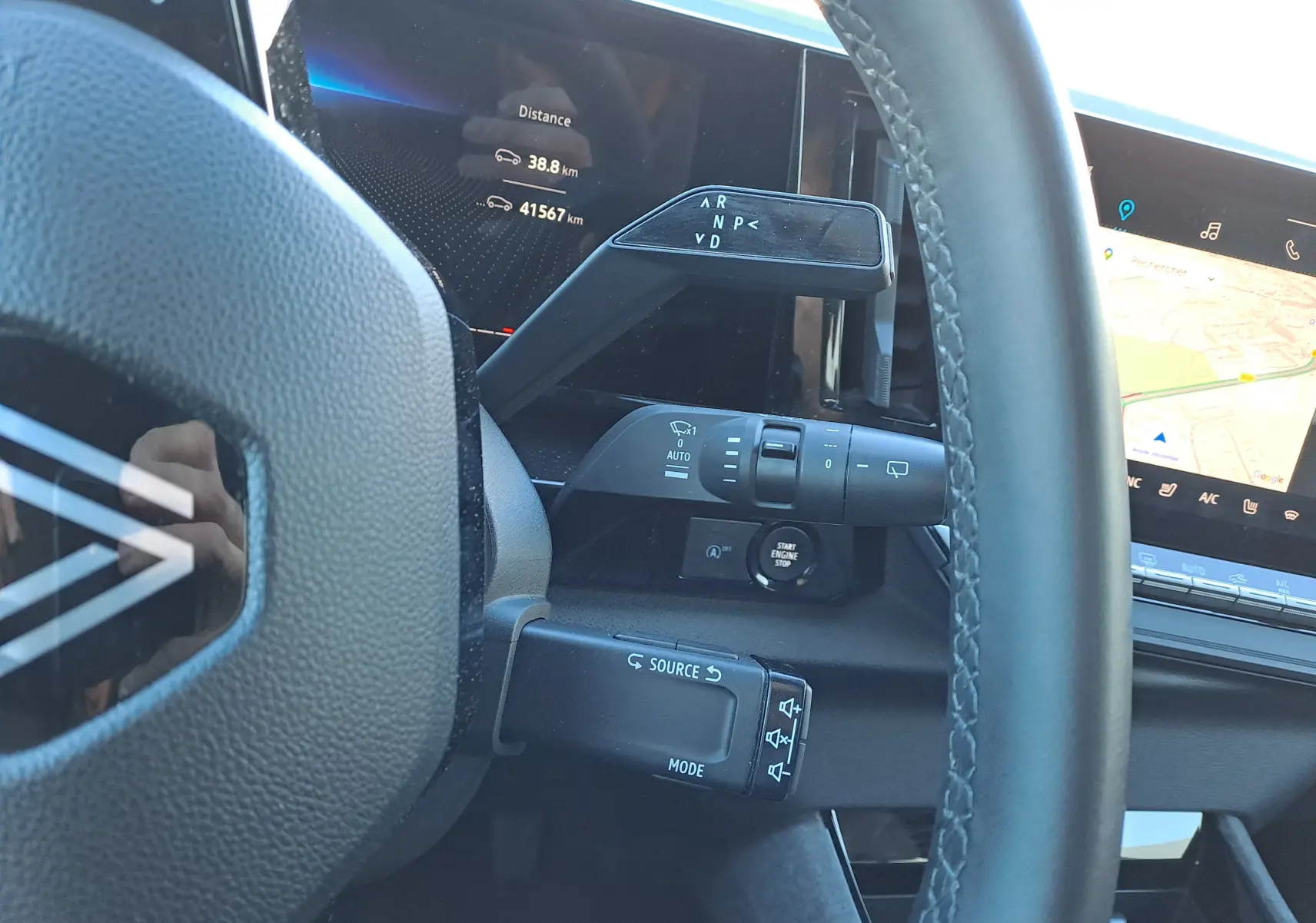 Vue rapprochée du volant et des commandes du tableau de bord d’un Renault Austral gris schiste avec écran tactile et affichage numérique.