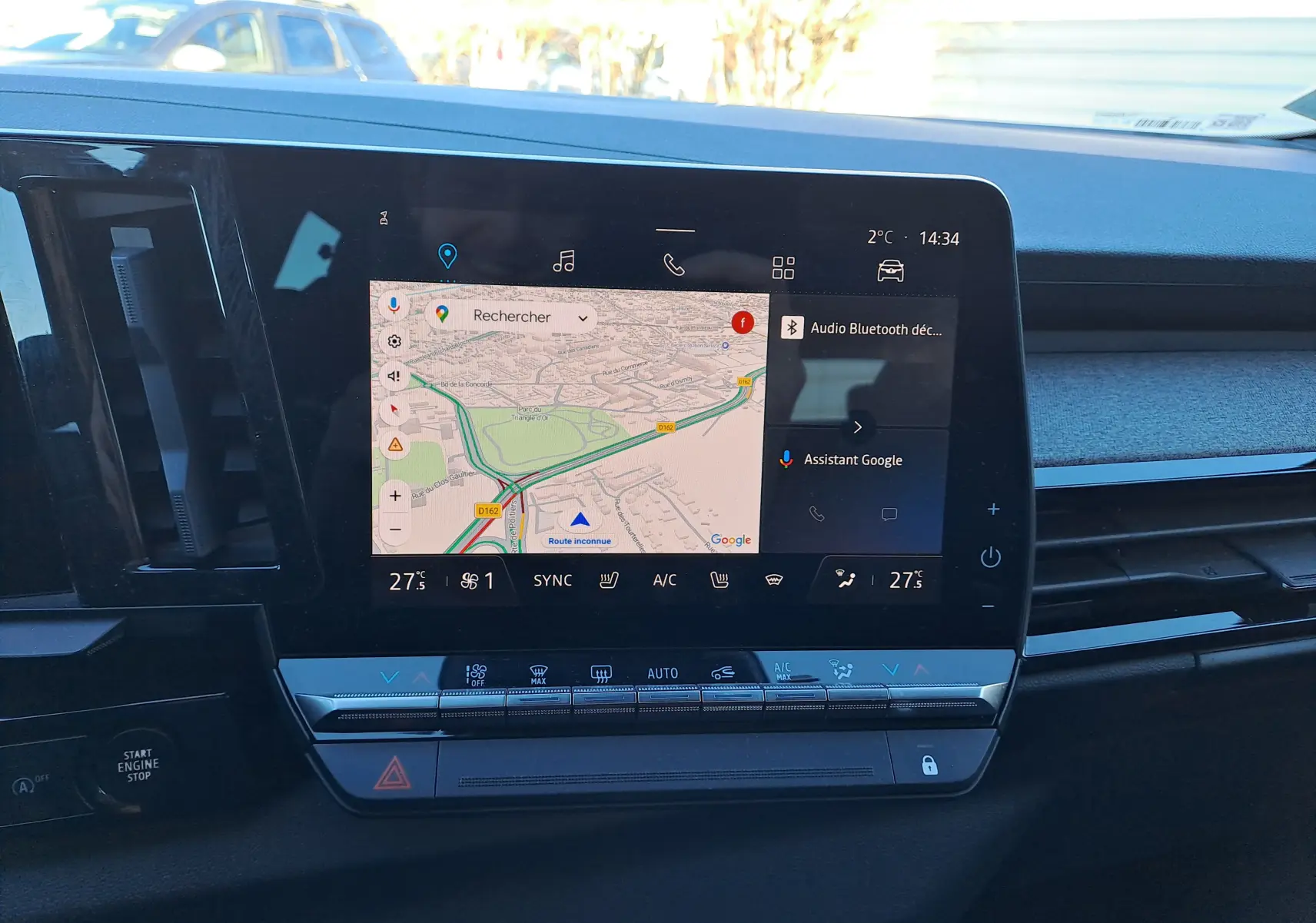 Vue rapprochée de l'écran tactile central du tableau de bord du Renault Austral gris schiste avec navigation et commandes climatiques.