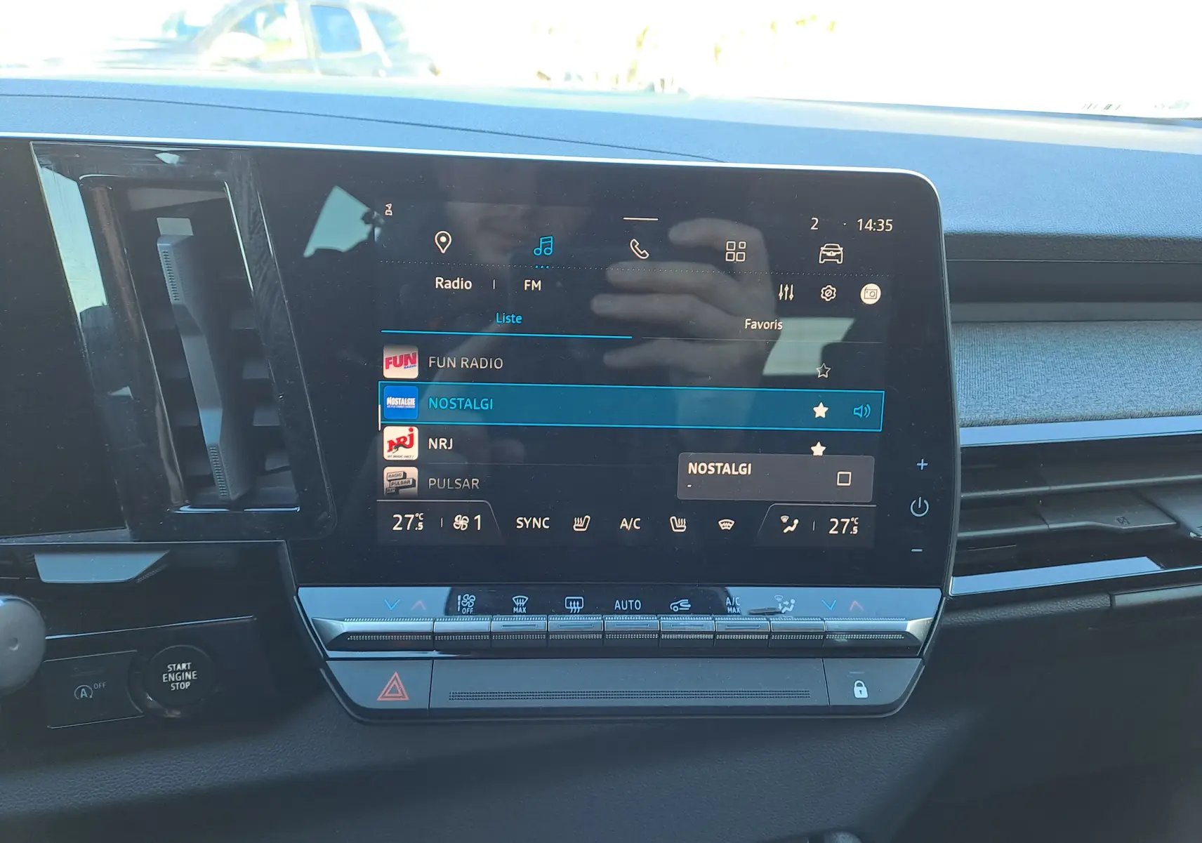 Vue intérieure centrée sur l'écran tactile multimédia du Renault Austral gris schiste avec commandes climatisation en dessous.